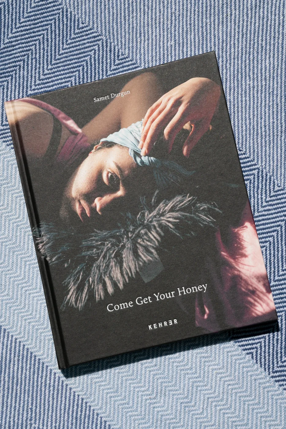 The book Come Get Your Honey resting on a striped blanket.